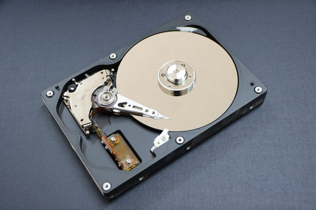 An opened hard drive showing its platter and read arm